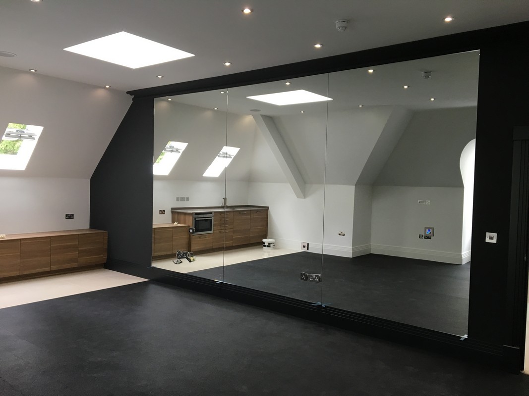 Frameless glass wall dividing loft conversion in Holloway